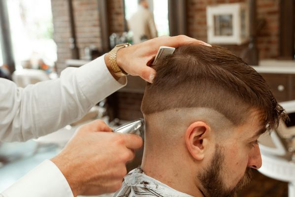 Un barbiere al lavoro con il rasoio elettrico